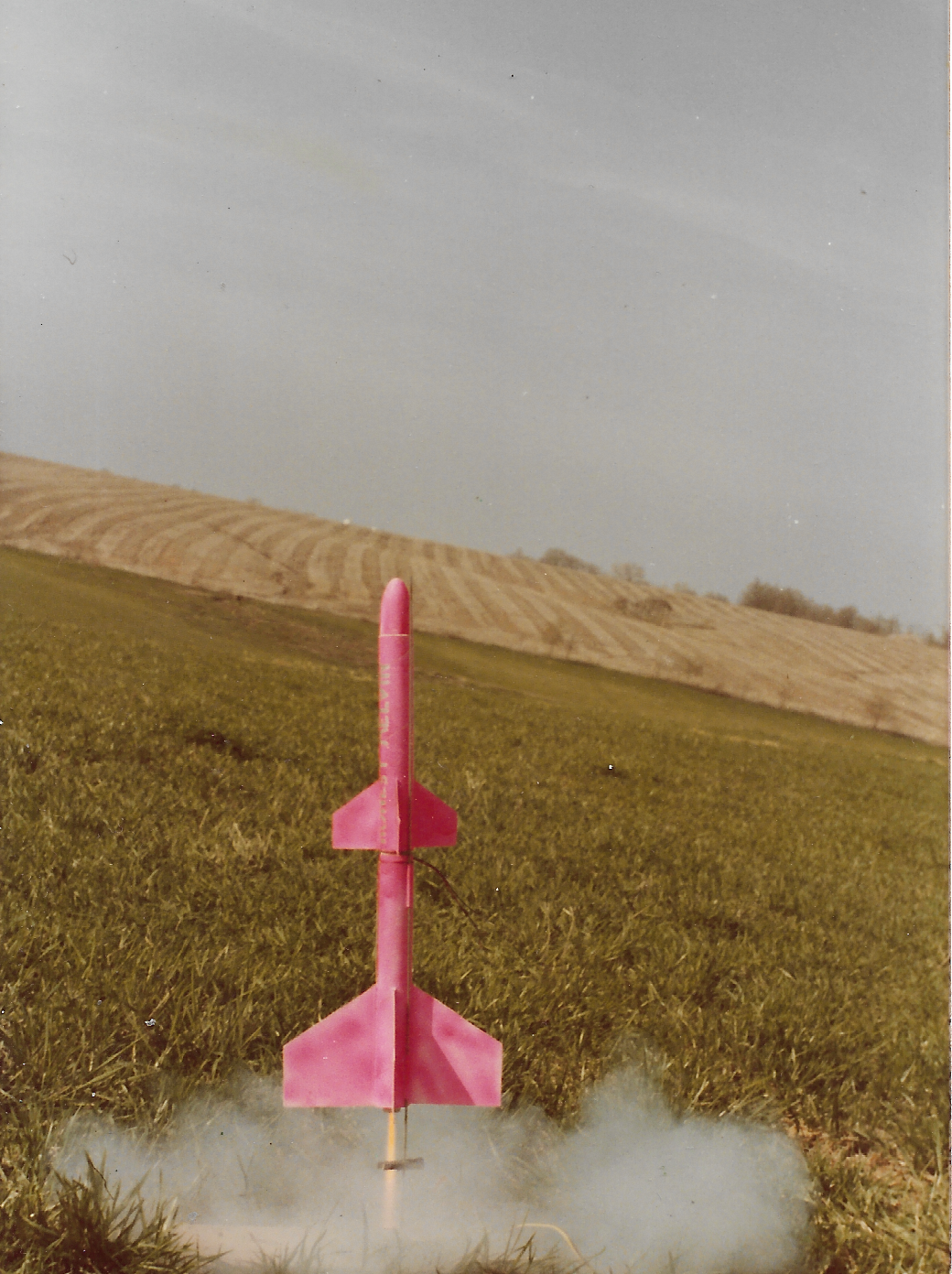 Bright pink model rocket lifting off